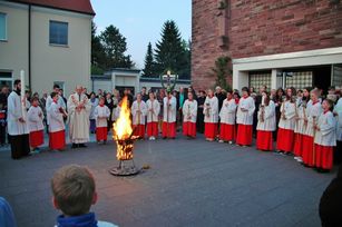 Am großen Osterfeuer auf dem Kirchplatz wird die Osterkerze gesegnet und entzündet.